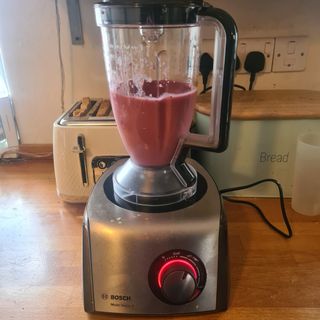 The Bosch MultiTalent 8 food processor on a kitchen counter - the mixing jug half full with a pink smoothie
