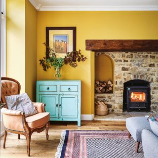 yellow living room in a country home with wood burner and traditional furniture
