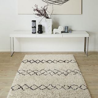 white wall with wooden flooring and rug