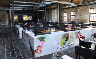 Some of Elmar Lause's street art decked seating areas at the open plan dining Bullerei eatery in Hamburg
