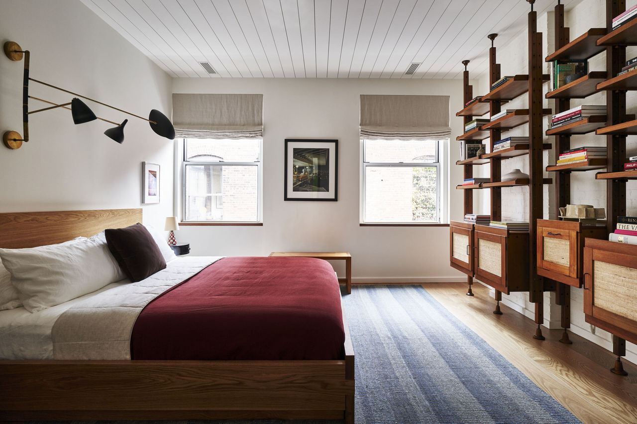 A bedroom with dark red sheets 