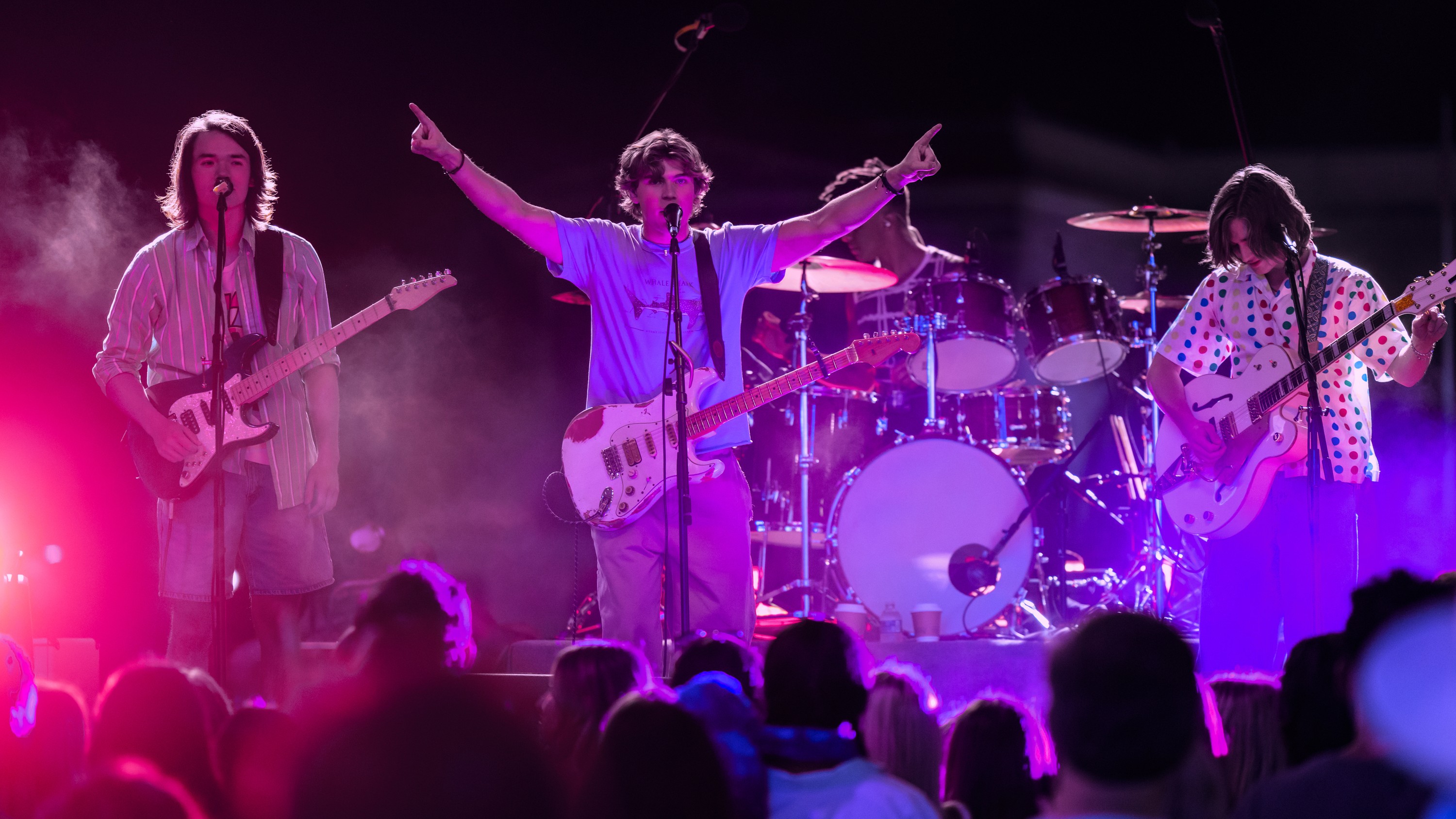 Topher (Jeremy Yun), Charlie (William Lipton) and Neil (Axel Ellis) performing on stage in a scene from Prime Video's "The Runarounds"
