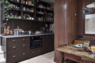 Small country kitchen with traditional browngloss kitchen cabinets and eclectic kitchen accessories