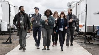 (L-R) Himesh Patel, Isaac Powell, Lolly Adefope, Jessica Hynes, Aya Cash, Daniel Brühl walking side-by-side on set in HBO's "The Franchise"