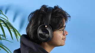 a pair of black bluetooth headphones made by OneOdio Focus A5 is photographed against a blue background