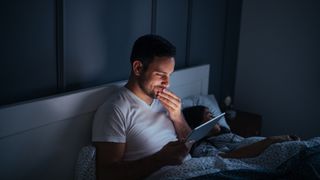 Sleep week man reading kindle in bed