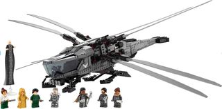 tiny plastic figures stand beside a toy spaceship with two sets of wings resembling a dragonfly