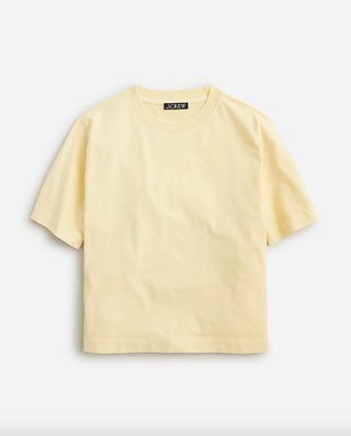 a butter yellow t shirt from jcrew in front of a plain backdrop