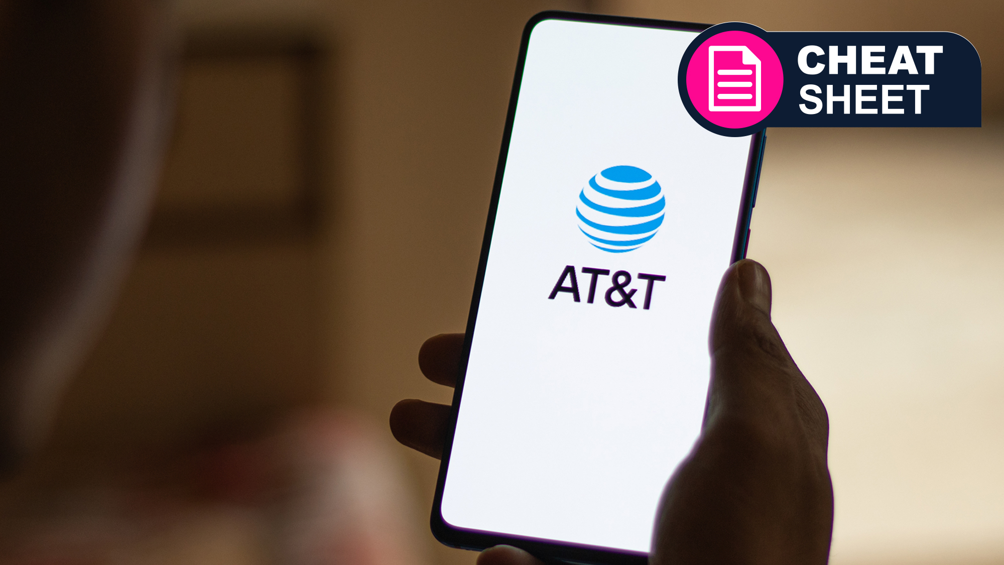A hand holding a phone with the AT&amp;T logo