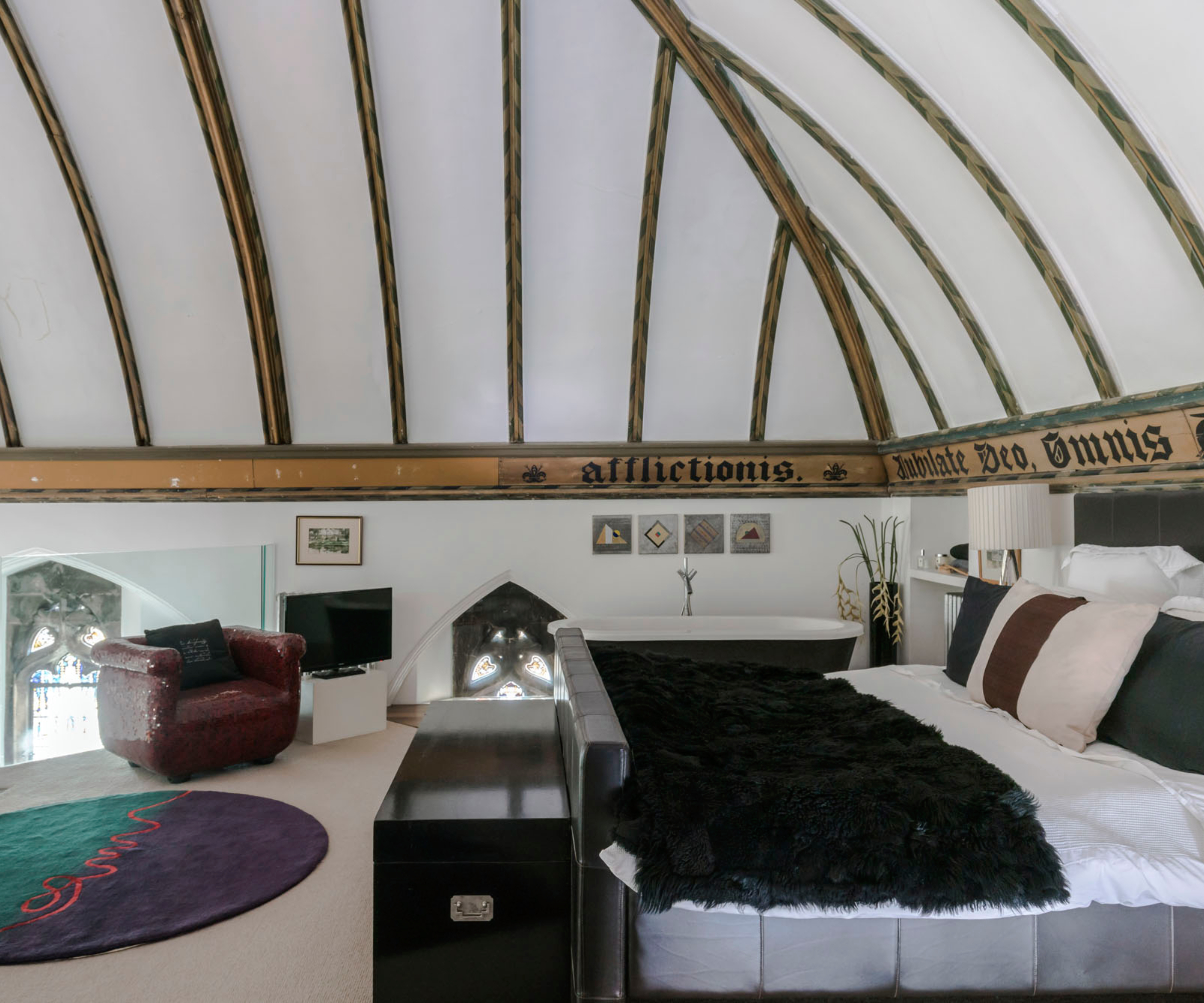 mezzanine bedroom with latin frieze and glass half height wall