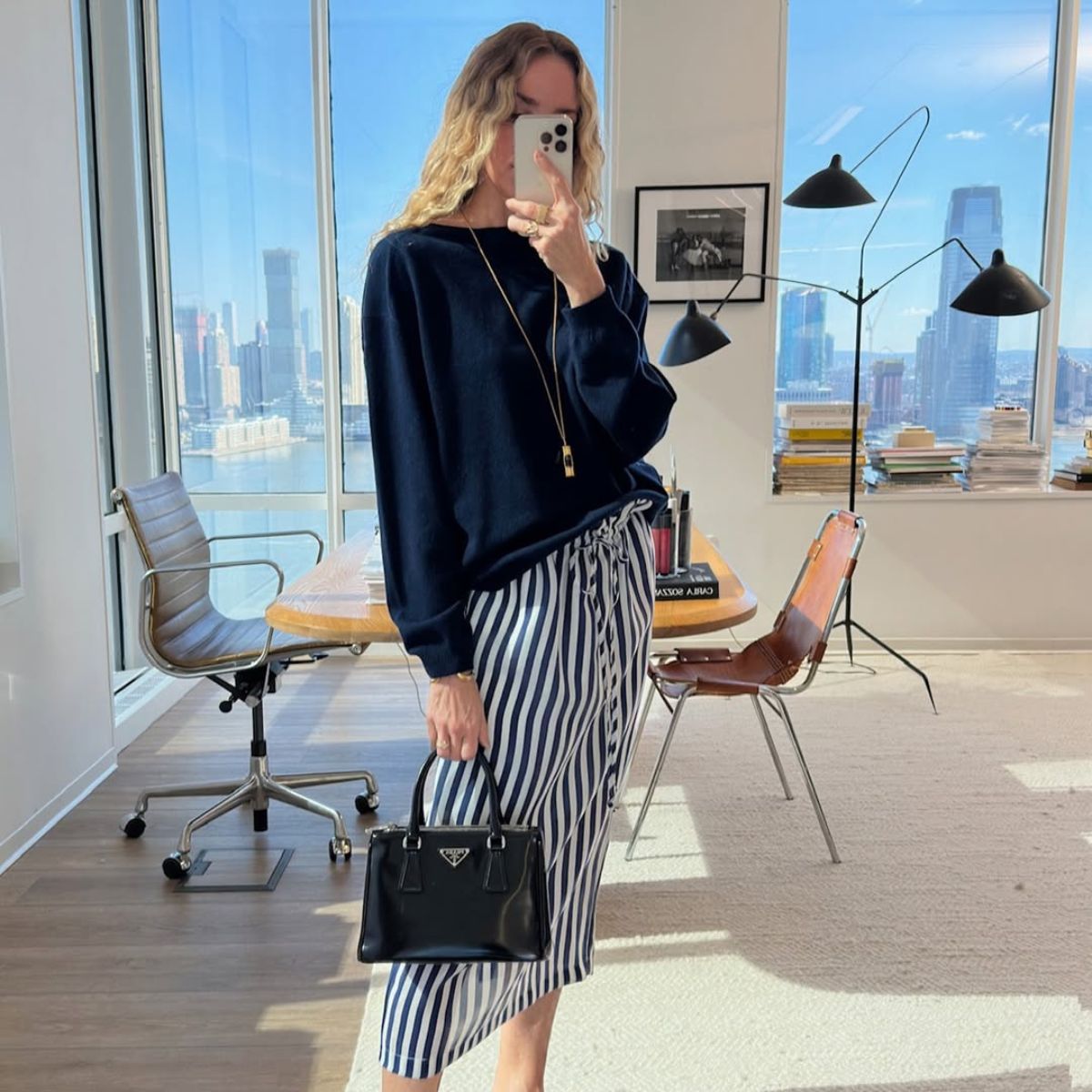 olympia gayot wears a cashmere jumper and striped skirt