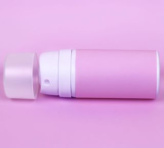 a pink deodorant can on pink background - GettyImages-1141680569