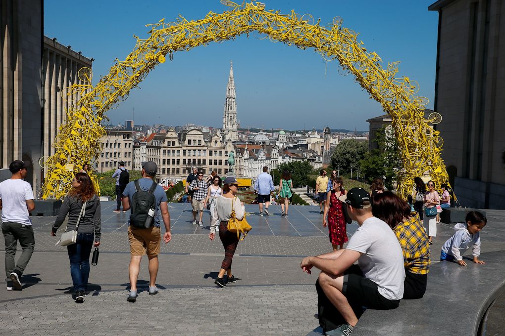 Passersby walk near the Grand-Place - Grote Markt in Brussels on June 28, 2019 past an arcade made with bikes painted in yellow
