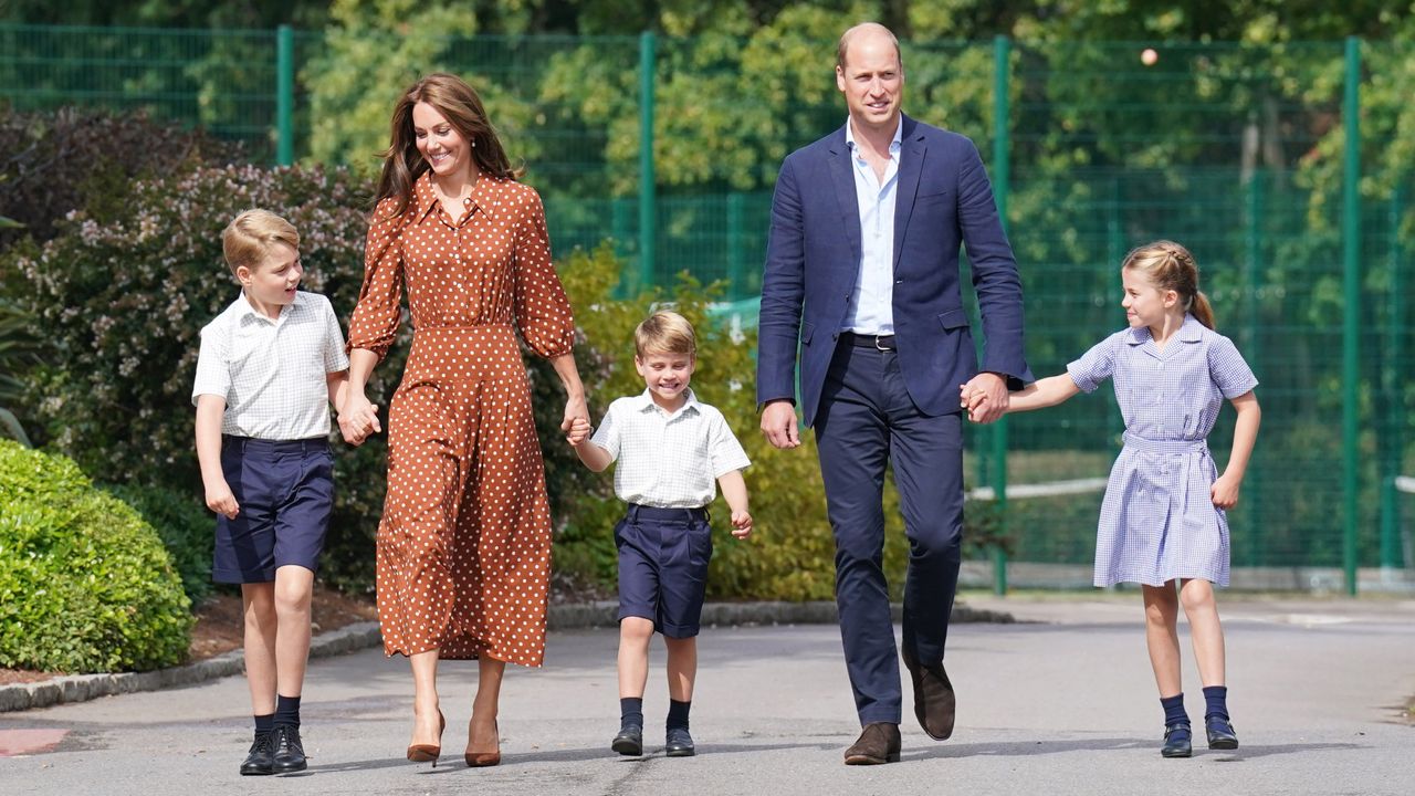 Prince George, Princess Charlotte, Prince Louis holding hands with Princess Kate and Prince William and wearing school uniforms walking to school