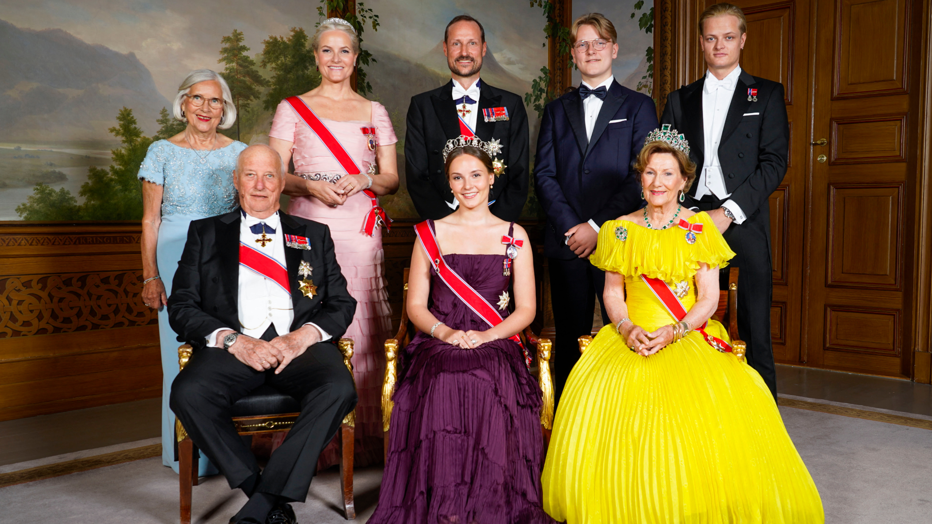 Queen Sonja and King Harald posing with members of the Norwegian royal family in gowns and tuxedos