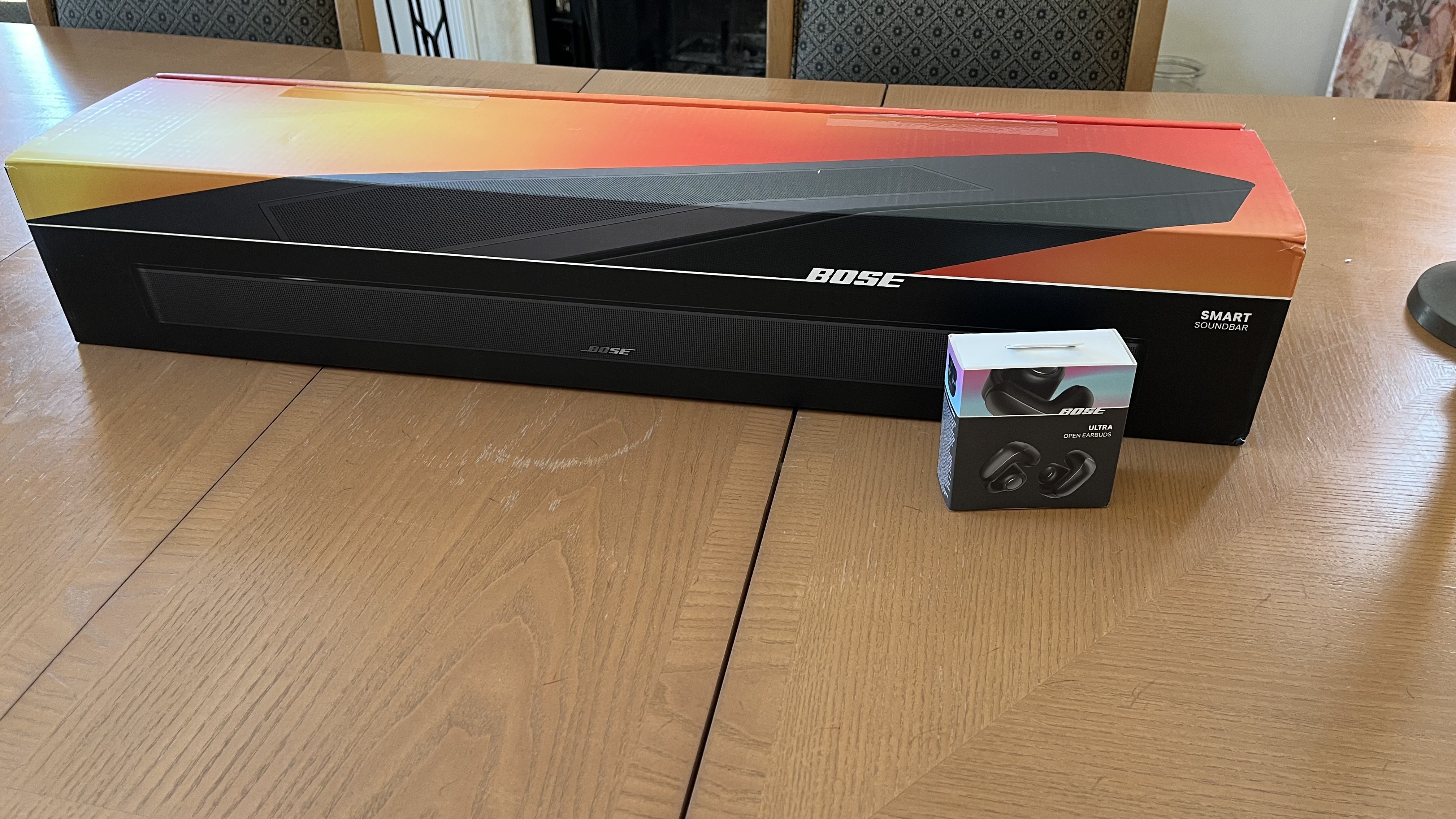 Bose Smart soundbar in box on floor with earbuds