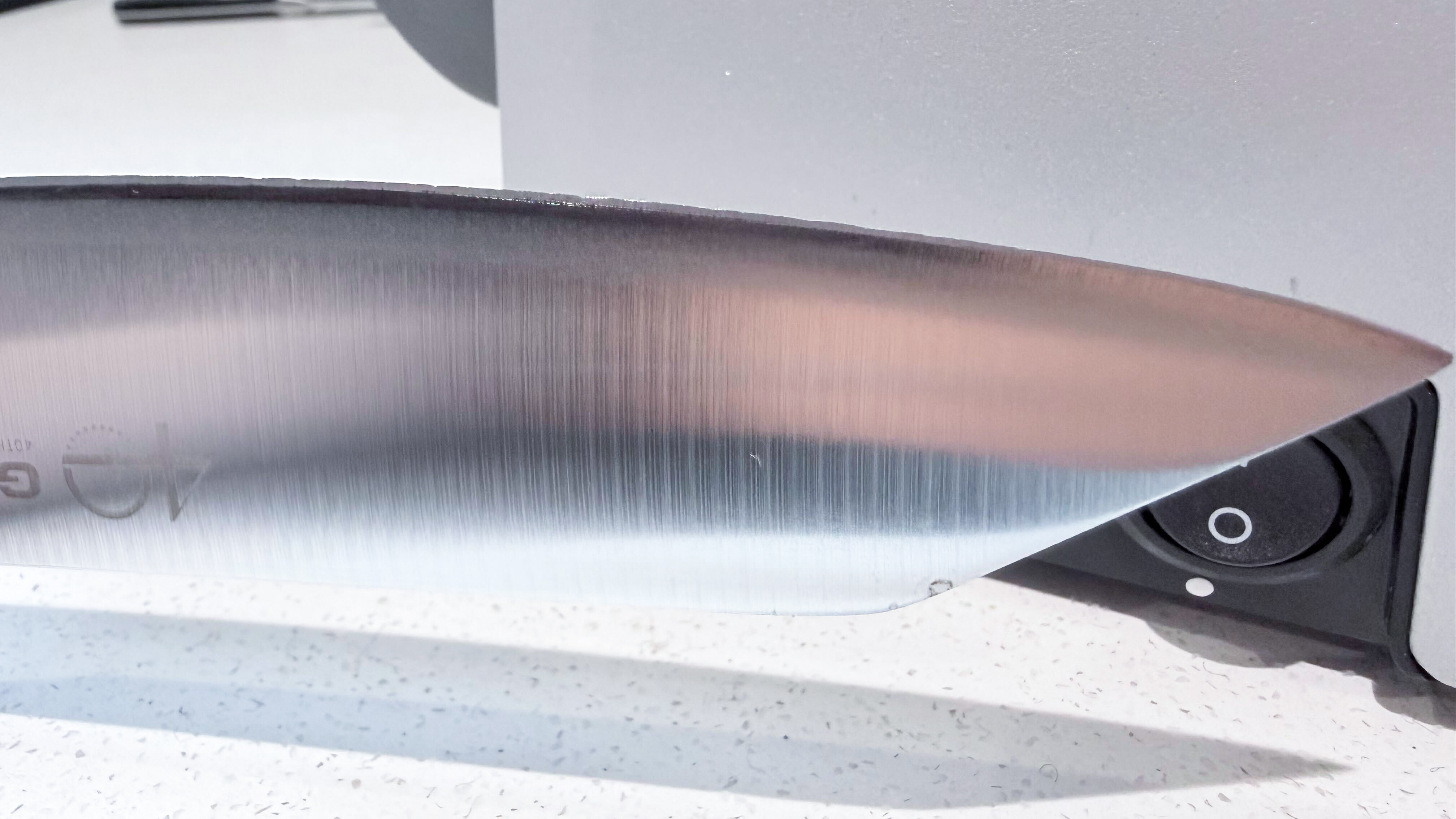 An image showing the edge of a Global chef's knife, with knicks and dents in the edge