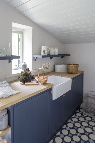 blue laundry room with patterned floor tiles by Gunter & Co