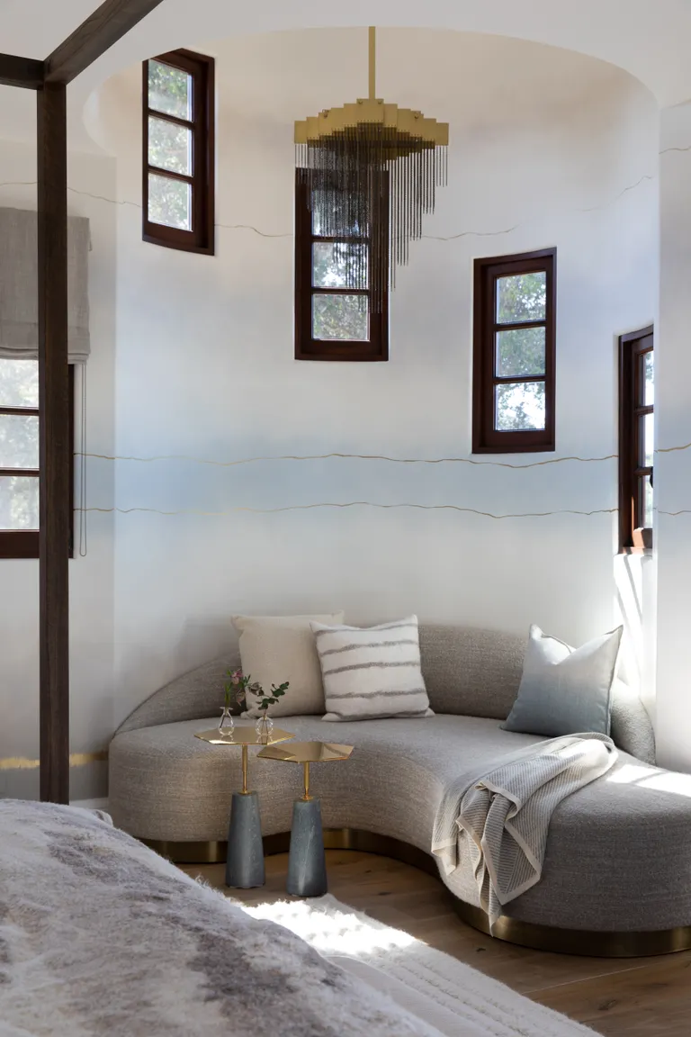 A bedroom with curved seating around the corner