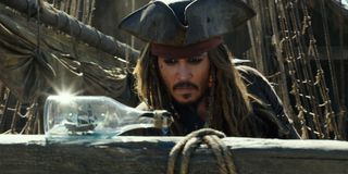 Jack Sparrow looking at a ship in a bottle