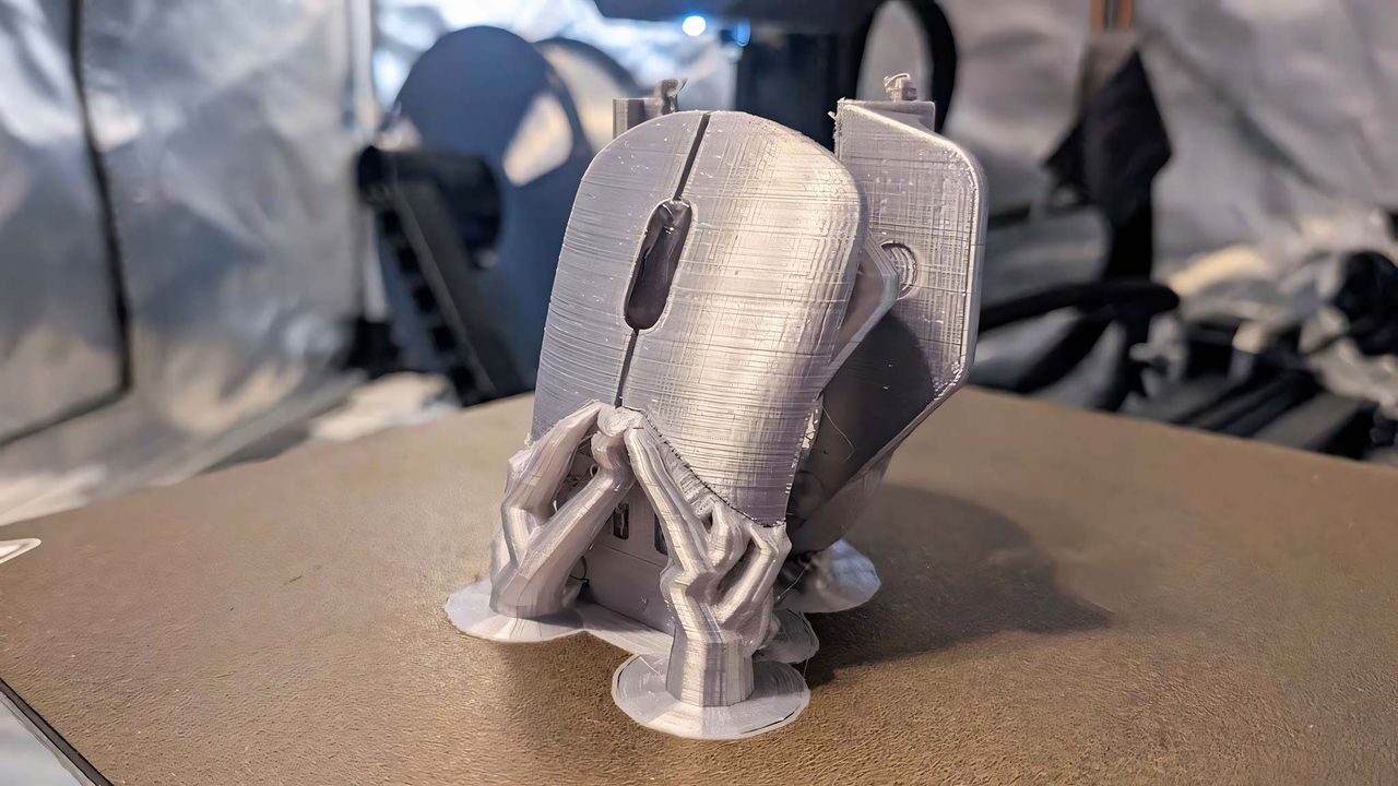 Silver shells 3D printed for HyperX Pulsefire Saga Pro Wireless and still on the printing tray.