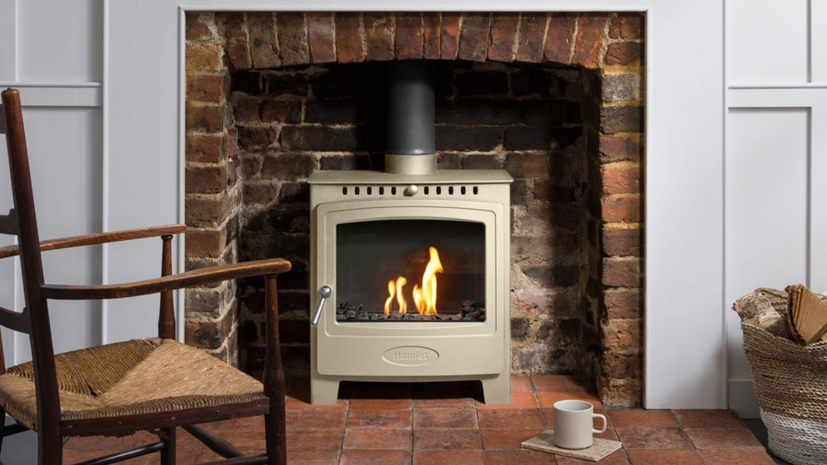 sage green log burning stove in brick fireplace with quarry tiled hearth
