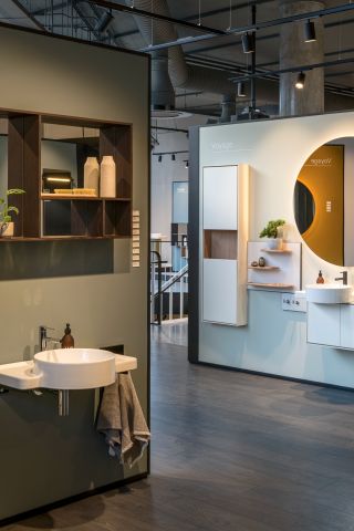 Inside the bathroom showroom featuring a circular sink units with fittings (shelf units, large circular mirrors; individual shelfs).