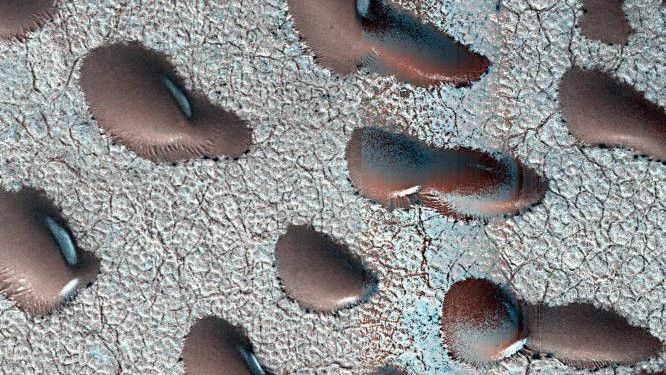 Frozen sand dunes sit locked in place in Mars&#039; northern hemisphere, stuck until the spring thaw melts their icy shells