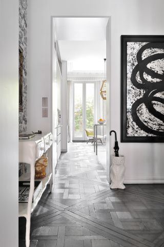 Entryway with table, tile floor, artwork and umbrella stand