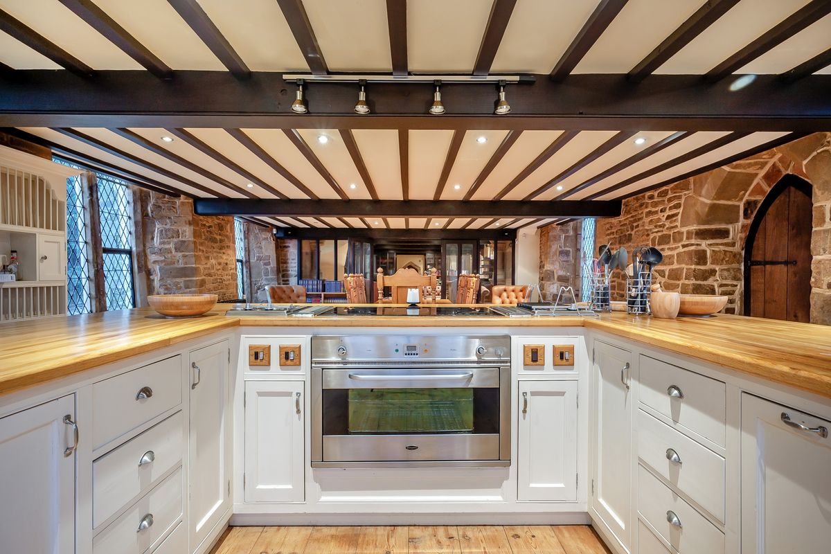A white U-shaped kitchen island with bespoke white units