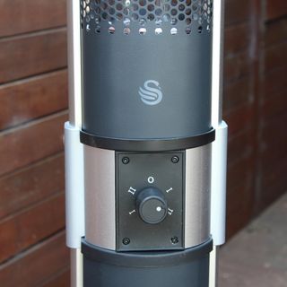 The Swan column patio heater controls being tested on a wooden deck