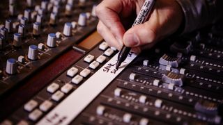 Man marking up the tracks on a mixing desk