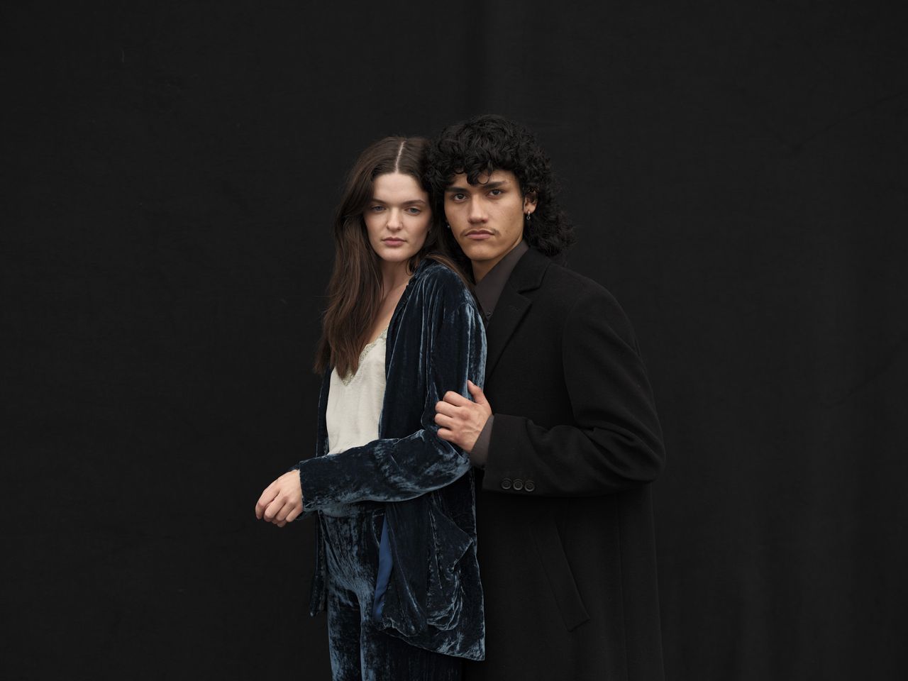Portrait of two models in front of black background