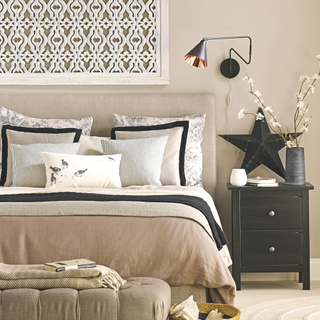 A monchrome bedroom in black white and beige.