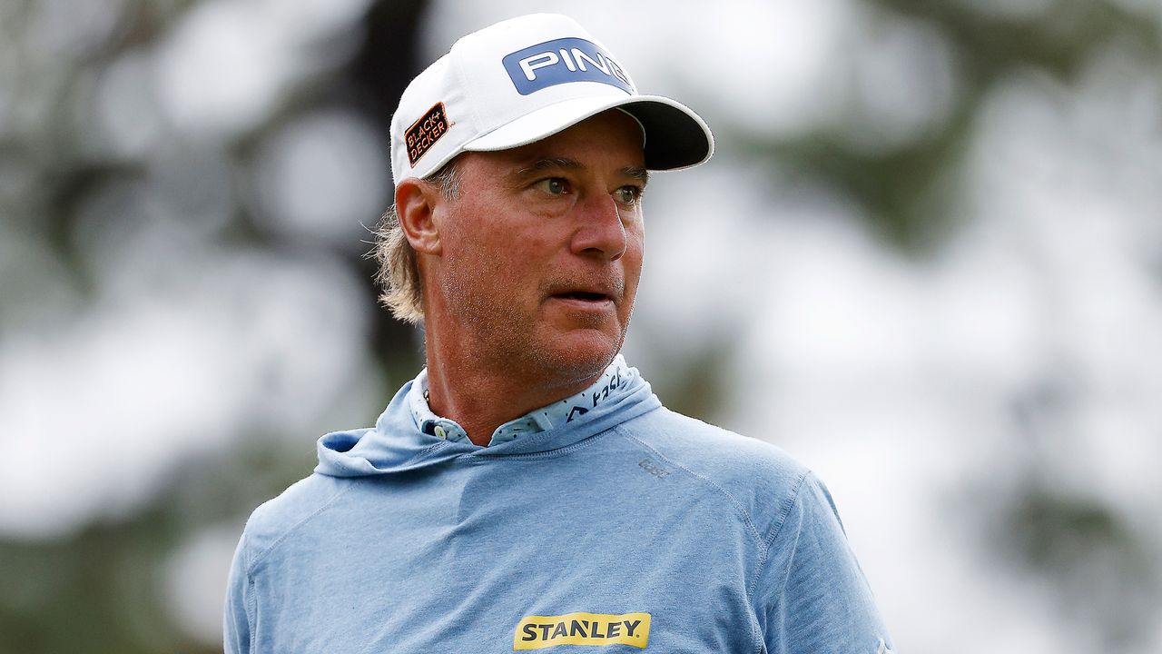 Chris DiMarco during a PGA Tour event wearing a white Ping cap and sky blue hoodie