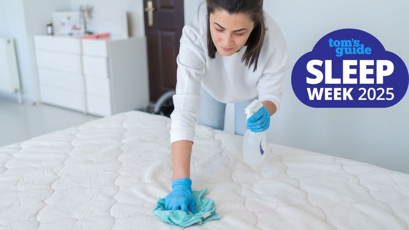 A woman scrubbing the surface of a mattress with a blue sponge with a Sleep Week 2025 logo in the corner