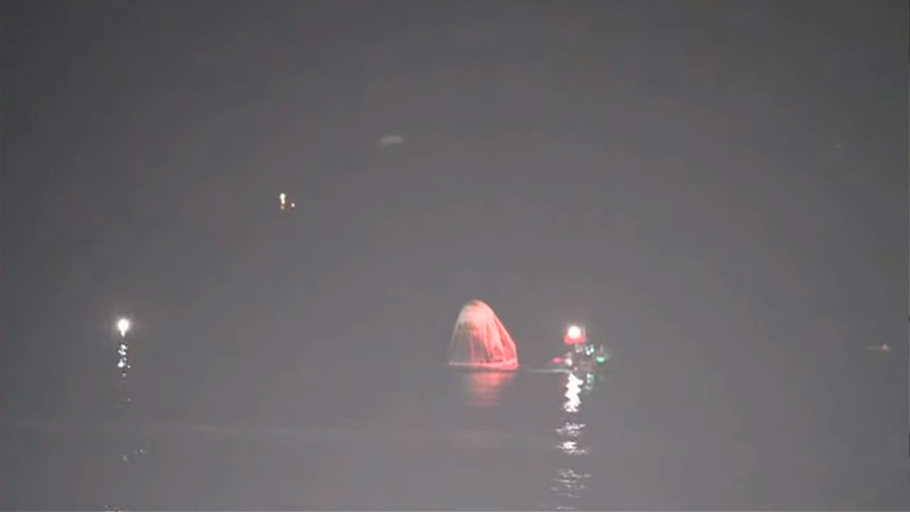 Thew Crew Dragon "Resilience" bobs in the Gulf of Mexico as recovery crews head over to pull the capsule from the water.
