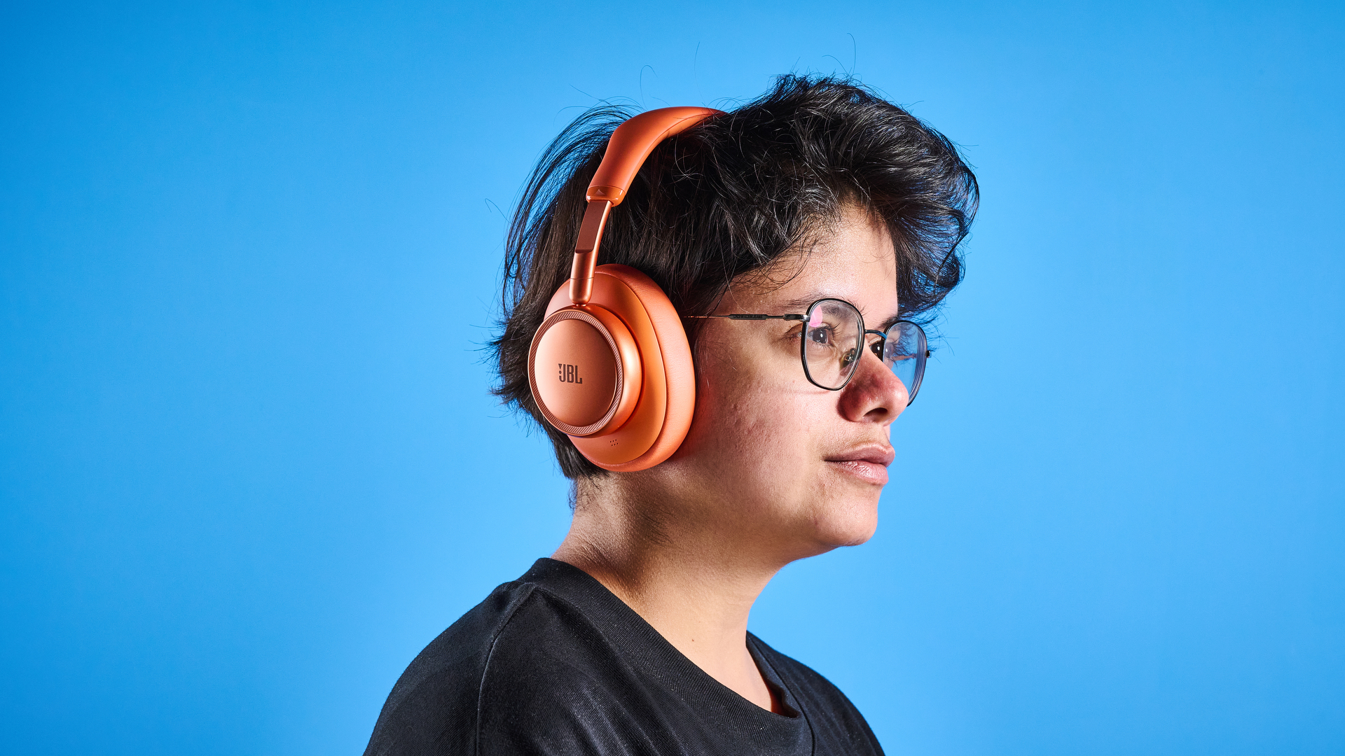 the jbl live 780NC in orange photographed against the blue tom's guide background