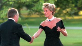 Princess Diana shaking a mans hand whilst she wears the controversial off the shoulder black dress with a statement pearl neckalce