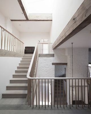 A photo of a staircase and beams in the ceiling.