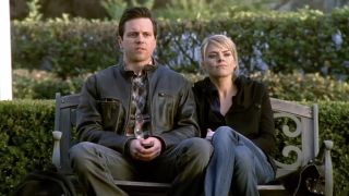 Michael Mosely and Eliza Coupe seated next to each other on a bench in Scrubs Season 9