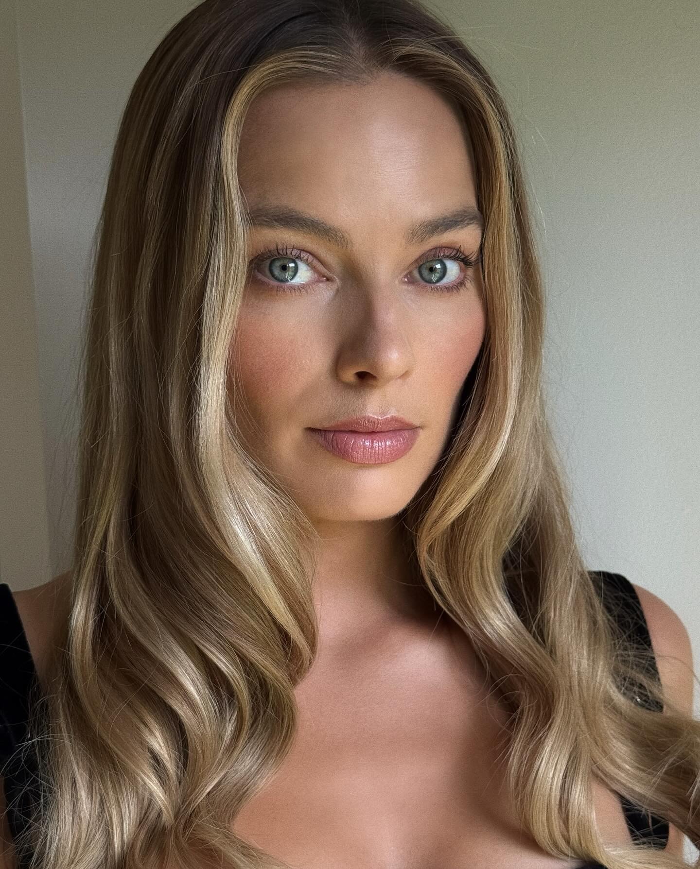 Margot Robbie with marbled blonde hair colour and long, softly curled hair