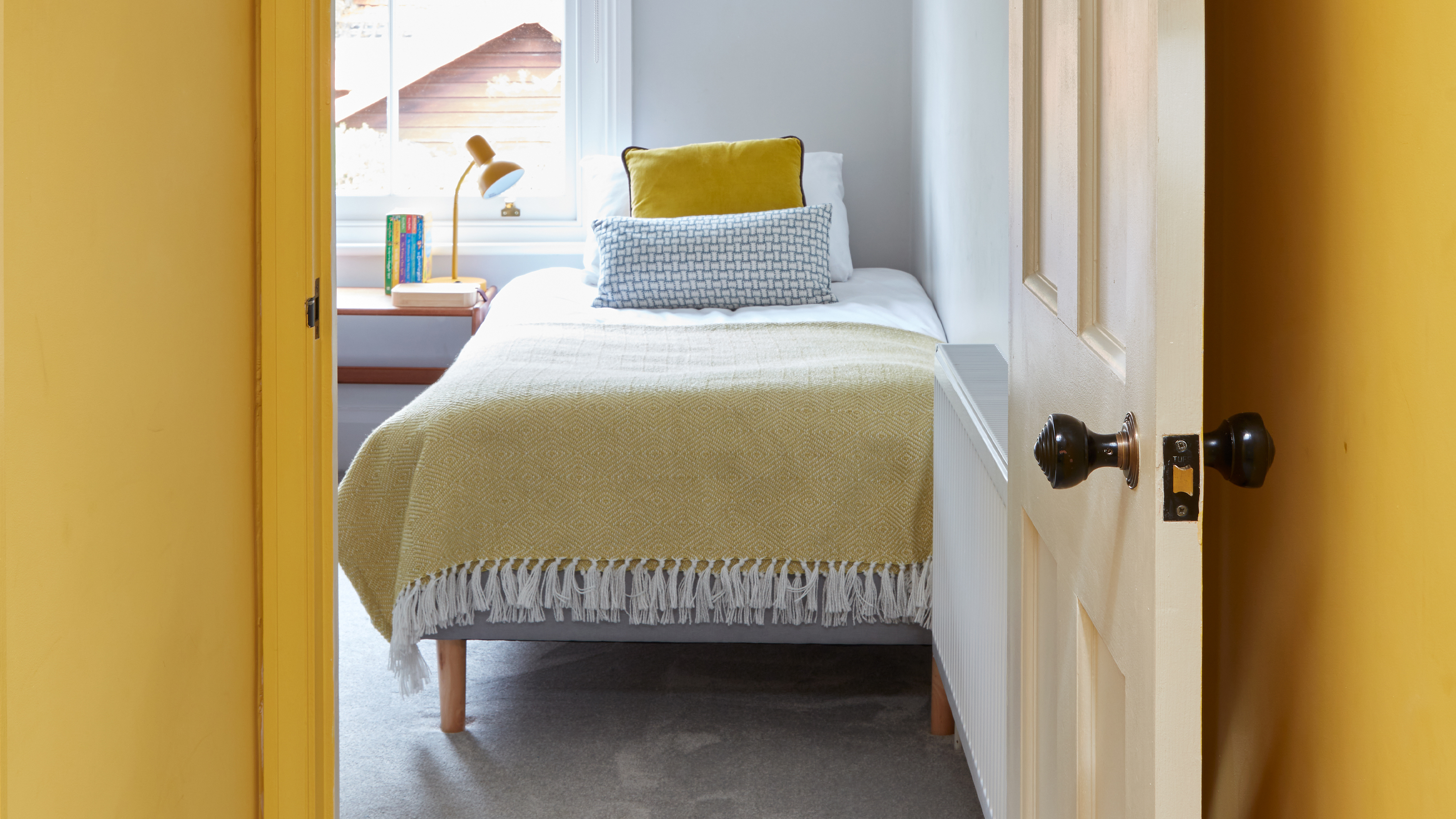 An open doorway revealing a yellow childrens bedroom