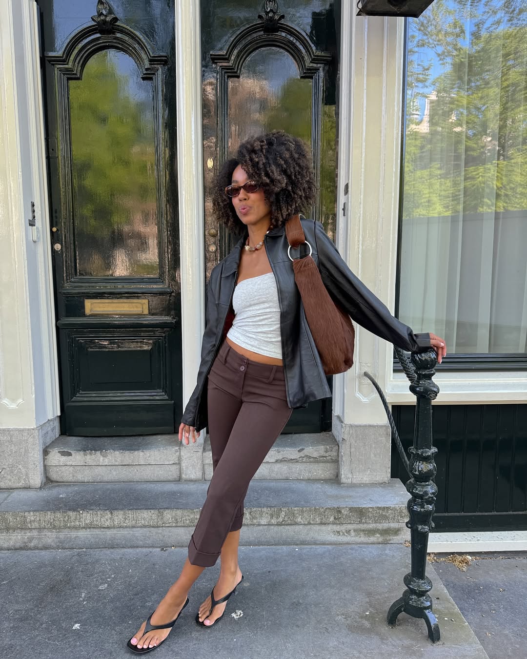 fashion influencer in capri trousers and leather jacket
