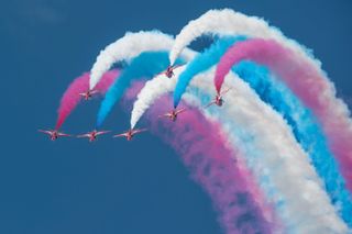 Red Arrows aerial display with streaming colored smoke