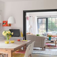 living room and dinning area with white wall dinning table and chairs sofa sets and glass doors