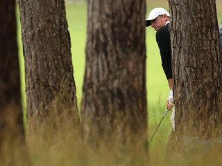 Rory McIlroy hitting a shot from the trees at the BMW PGA Championship