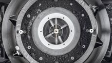 View of the OSIRIS-REx Touch-and-Go-Sample-Acquisition-Mechanism (TAGSAM) head with lid removed, unveiling the bulk of asteroid Bennu sample inside.