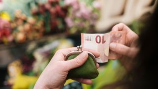 woman holding coin purse and 10 euro note