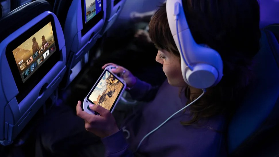 Woman using headphones and Nintendo Switch on United Airlines flight